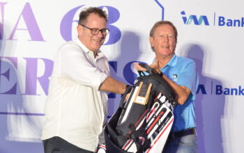 Dave Plenderleith (right) receives a golf bag from I&M Bank CEO Robin Bairstow